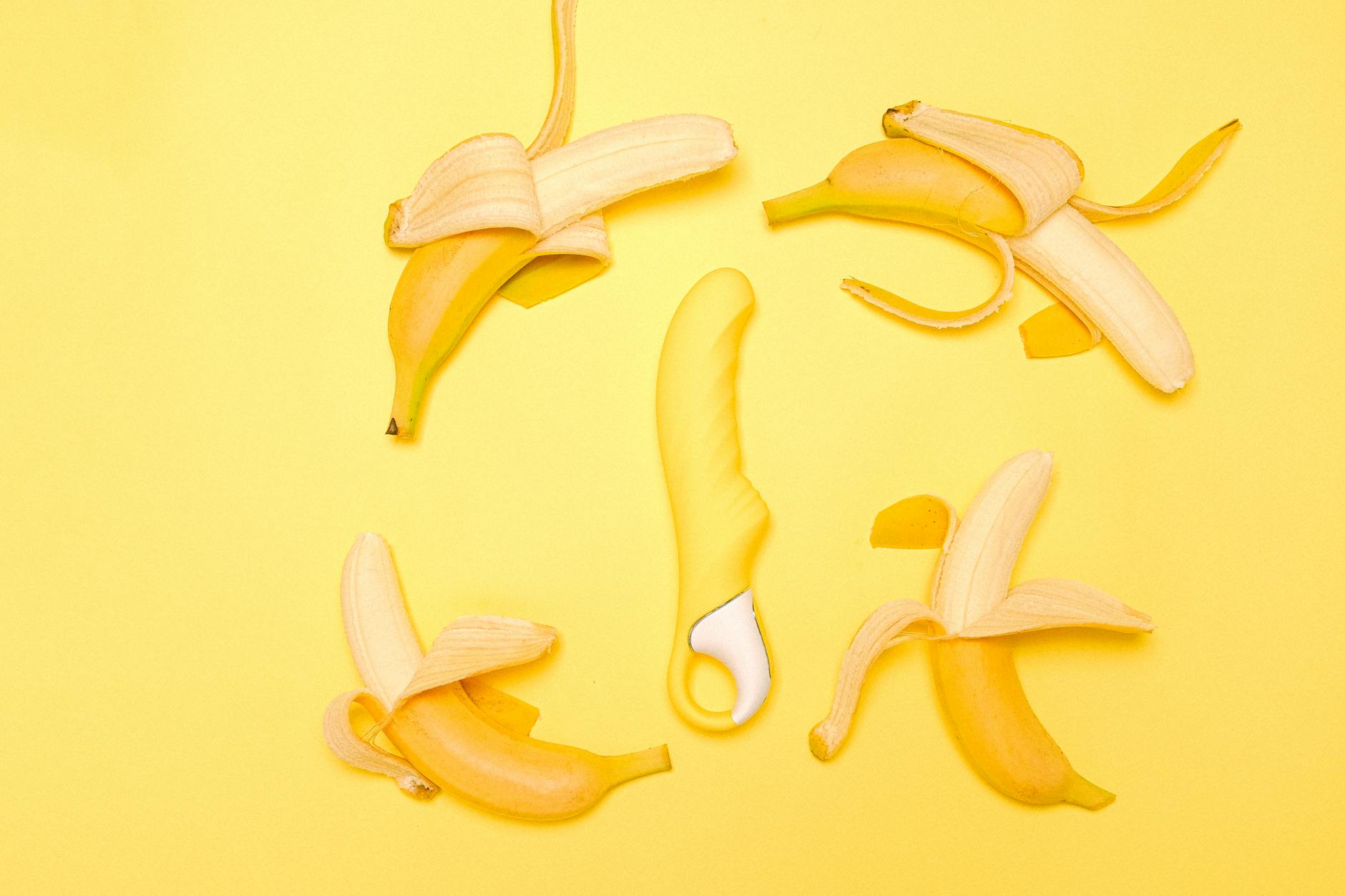 Yellow lemon-shaped vibrator surrounded by fresh lemons on a bright background, symbolizing approachable pleasure