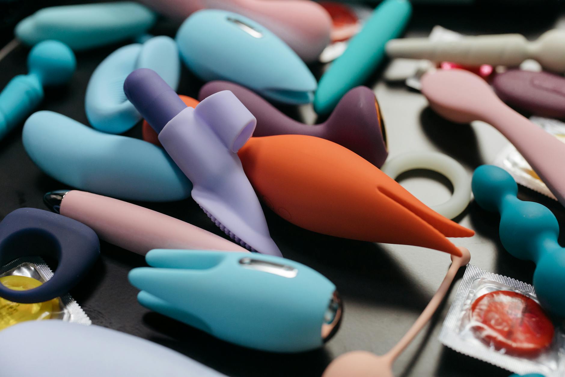 Vibrant collection of colorful vibrators arranged on a bright yellow surface